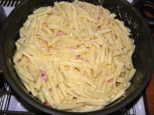 Dodati ocijeđenu tjesteninu, jaja, parmezan i vrhnje za kuhanje